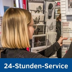 Foto einer jungen Frau, die vor einem Grußkartenständer steht. Beworben wird der 24-Stunden-Online-Service